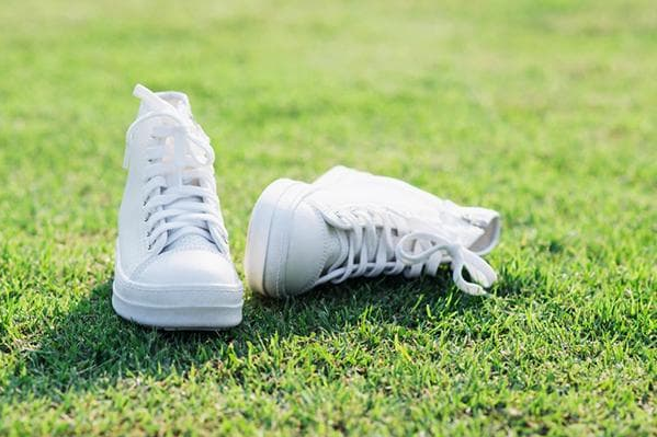 Білі кеди на газоні